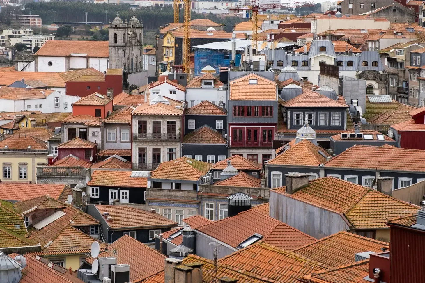 A imagem mostra um aglomerado de casas e edifícios tradicionais, característico do centro histórico do Porto, em Portugal